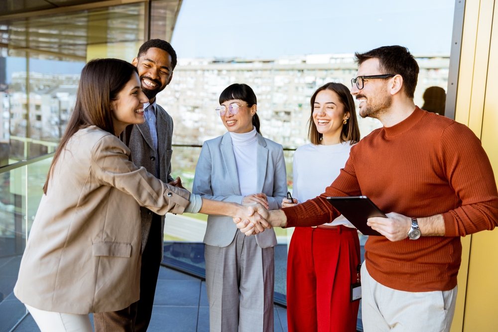 A Lively Gathering Of Professionals In A Bright Office