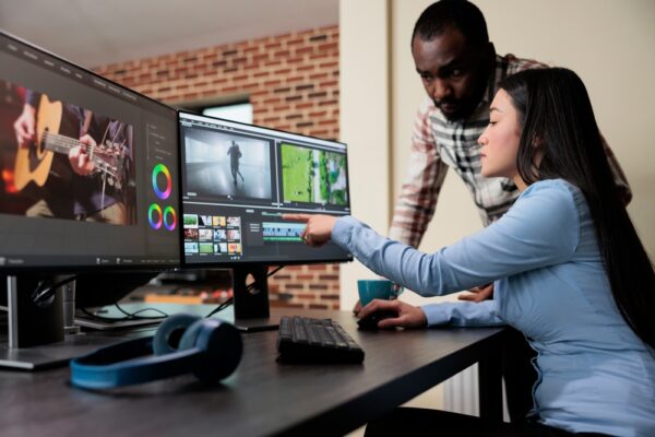 Professional Digital Movie Editor Sitting At Desk While Improving Film